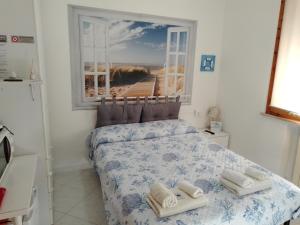 a bedroom with a bed with towels on it at La Casa di Berenice a Porto Azzurro in Porto Azzurro