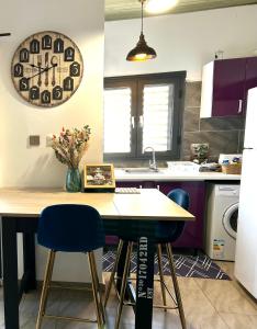 cocina con mesa de madera y sillas azules en Appartement entier, T2 cosy à Mamoudzou, en Mamoudzou