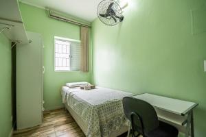 Schlafzimmer mit einem Bett, einem Schreibtisch und einem Fenster in der Unterkunft HOSTEL HOME ACADEPOL METRO BUTANTA e USP in São Paulo