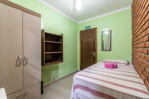 a bedroom with a bed and a brick wall at HOSTEL HOME ACADEPOL METRO BUTANTA e USP in Sao Paulo