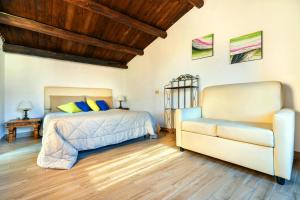 パレルモにあるAppartamenti Olivuzzaのベッドルーム(ベッド1台、ソファ付)