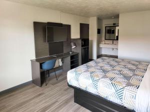 ein Hotelzimmer mit einem Bett und einem Schreibtisch in der Unterkunft Motel 6 Oklahoma City OK Frontier City in Edmond