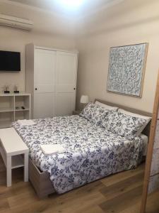 a bedroom with a bed with a blue and white comforter at Cami s holidays home in Catania