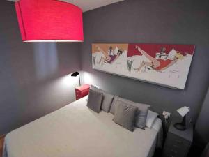 ein Schlafzimmer mit einem weißen Bett und einer roten Lampe in der Unterkunft Cosy apartment at Unesco Heritage city in La Laguna