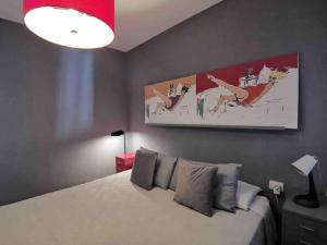 ein Schlafzimmer mit einem Bett und ein Katzengemälde an der Wand in der Unterkunft Cosy apartment at Unesco Heritage city in La Laguna