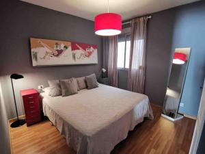 ein Schlafzimmer mit einem weißen Bett und einer roten Lampe in der Unterkunft Cosy apartment at Unesco Heritage city in La Laguna