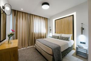 una camera d'albergo con un letto e una grande finestra di Andrew's Luxury Residence a Nauplia