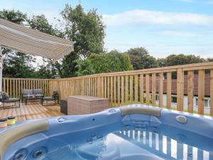 a swimming pool on a deck with a wooden fence at 6 Manorcombe Bungalows in Callington