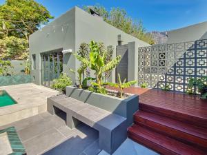 a garden with a bench and a house at Virginia Avenue Villas - Adriatica and Botanica in Cape Town