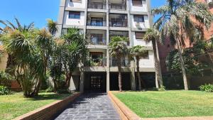 ein Gebäude mit Palmen davor in der Unterkunft Alquiler temporario en Vicente López in Vicente López