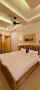 a bedroom with a large bed with white sheets at Hotel Kamal Nearest To Taj Mahal in Agra