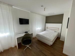 een slaapkamer met een bed, een bureau en een stoel bij ART Hotel Ufer in Düsseldorf