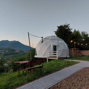 ein Zelt auf einem Hügel mit einem Tisch in der Unterkunft SlavskoGlamping in Slawske