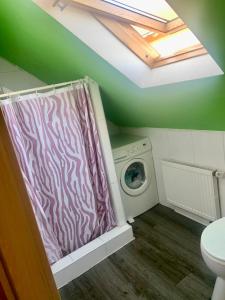 a laundry room with a zebra shower curtain and a washing machine at Übernachtung Möglichkeit in Eitensheim