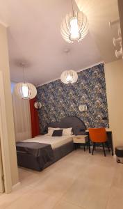 a bedroom with a bed and two chandeliers at OITUZ Boutique Residence in Mangalia