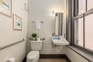 a white bathroom with a toilet and a sink at Deluxe 5-bedroom Walk everywhere in Over the Rhine in Cincinnati +32 photos
