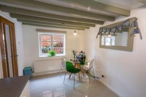 a dining room with a table and a mirror at Southwell Holiday Cottage - Lavender Cottage in Southwell