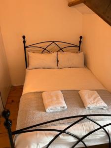 uma cama com duas almofadas num quarto em The Cottage St Kew em Port Isaac