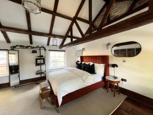 um quarto com uma cama grande num quarto com tectos em madeira em Riverside Mews - Yarm High Street em Yarm