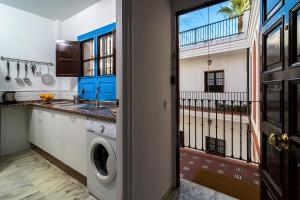 a kitchen with a washer and dryer next to a door at More Center Apartment in Seville