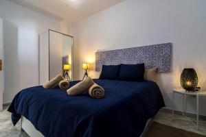 - une chambre dotée d'un lit bleu avec deux oreillers dans l'établissement More Center Apartment, à Séville