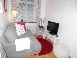 a living room with a couch and a flat screen tv at Herning City Apartments in Herning