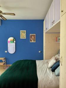 a bedroom with a blue wall and a bed at Apartment with Garden in Romano di Lombardia