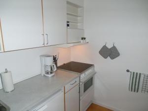 una pequeña cocina con armarios blancos y licuadora en Herning City Apartments, en Herning