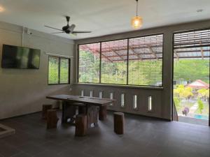 jadalnia ze stołem i oknami w obiekcie Pangkor Nature View House w mieście Pangkor