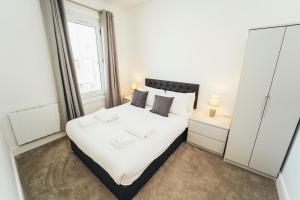 a bedroom with a large white bed and a window at Cottages in Derbyshire - Duffield Apartment in Duffield