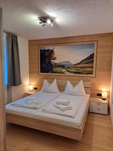 a bedroom with a white bed with two towels on it at Chalet Sabrina mit Außenpool im Sommer in Kaprun