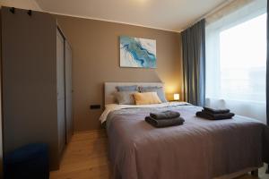 a bedroom with a bed with two towels on it at Kastani Apartments in Rakvere