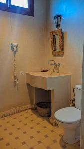 La salle de bains est pourvue d'un lavabo et de toilettes. dans l'établissement Ourika lodge the healing place, à Tafza