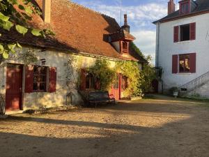 Pleasant cottage in Le Veurdre with private garden في Le Veurdre: مبنى قديم امامه مقعد