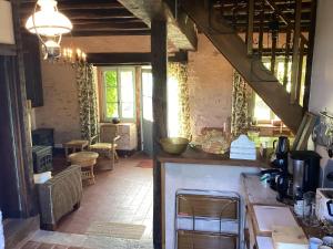 eine Küche mit einer Theke und einer Treppe in einem Zimmer in der Unterkunft Pleasant cottage in Le Veurdre with private garden in Le Veurdre