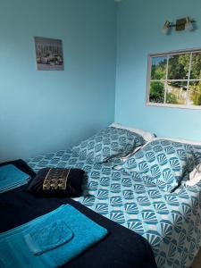 een slaapkamer met een bed met een blauwe muur bij L'étoile de mer in Bourcefranc +83 foto's