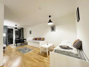 Cette chambre blanche comprend un lit et une table. dans l'établissement MUZETA11 - Modern Town Apartment with Balcony, à Vienne