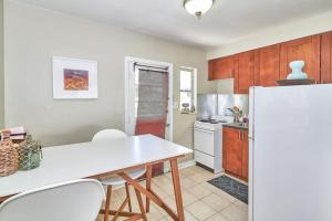 a kitchen with a white table and a refrigerator at Vinoy Beach getaway Fun in the Sun Close to bars in St. Petersburg