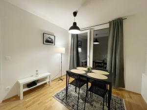 une salle à manger avec une table et des chaises noires dans l'établissement MUZETA11 - Modern Town Apartment with Balcony, à Vienne