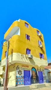 a yellow building with a sign on the side of it at Ghalia Guest House in Aswan