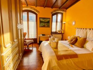 a bedroom with a large bed with yellow walls at La Rosa di Langa - Charming Panoramic House in Albaretto Della Torre 