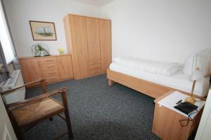 a bedroom with a bed and a desk and a chair at Lüttje Gesine Lüttje Gesine in Norderney