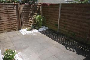 a backyard with a wooden fence and a patio at Lüttje Gesine Lüttje Gesine in Norderney