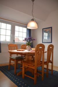 a dining room table and chairs with a table and a vase at Up Süderdün 7 Up Süderdün 7 in Norderney