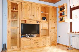 a living room with a wooden entertainment center with a television at Haus Sieberns Haus Sieberns in Norderney