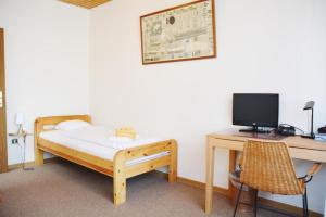 a bedroom with a bed and a desk with a computer at Haus Sieberns Haus Sieberns in Norderney