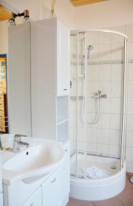 a white bathroom with a shower and a sink at Haus Sieberns Haus Sieberns in Norderney