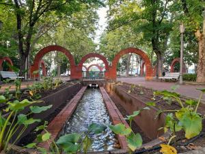 una fuente de agua en un parque con árboles y arcos en Apartamento Saioa en Pamplona