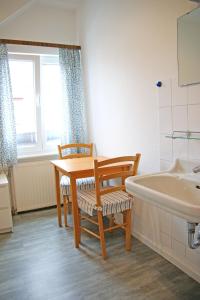 a bathroom with a table and chairs and a tub at Haus Wendland Haus Wendland in Norderney