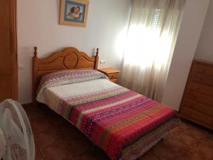 a bedroom with a bed with a colorful blanket at CONIL frente a la playa Carril De la Fuente in Conil de la Frontera